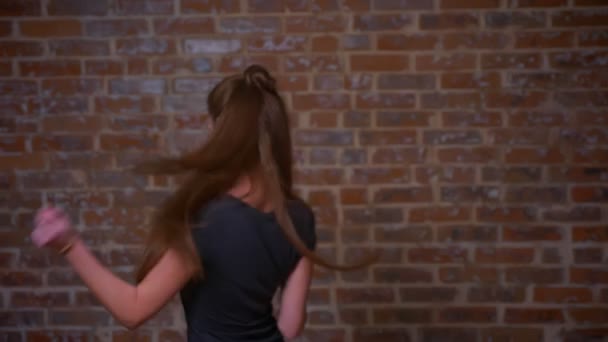 Gelukkig gek dansen beelden van gember Kaukasische vrouw in baksteen studio, casual stijl en grappige bewegingen binnen — Stockvideo