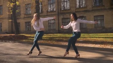 Keyifli sıcak beyaz kadın yalnız gençler içinde gerçekleştirmek ve mutlu bir şekilde dans adımları, Üniversitesi arka plan, yaz görünümünde antik kenti yapma