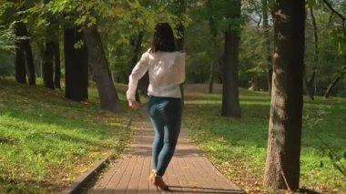 Arkadan ateş, güzel esmer beyaz kadın Latin tarzı bahar sıcak zaman, saf doğa, hareketleri yeşil park yolu üzerinde dans ediyor