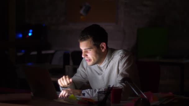 令人敬畏的高加索商人在他的桌面上工作, 使用电脑, 而它是黑暗的深夜在办公室, 集中和严重 — 图库视频影像