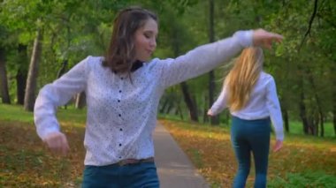 İki komik beyaz kız birlikte dışarı asılı, güzel yeşil Park atlama, bırakarak, dans ve yaşam, mutlu anları zevk atma