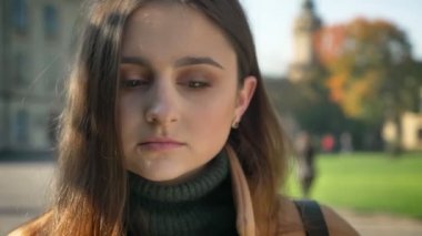 Güneşli hava çok güzel ve rahat yer arka plan üzerinde iken açık ve kamera düz bakarak duruyor beyaz kadının oldukça yakın çekim yüz