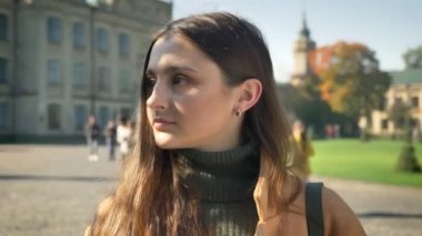 Sevimli beyaz stadning ve sürpriz jest, gösterilen elleriyle başını tutarak ve sheerfully açık, kentsel görünümü olurken kameraya gülümseyen kadındır