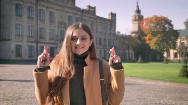 Oldukça sanatsal beyaz kadın düz duruyor ve onu tutmak için arka plan, açık alan ve güneşli illüstrasyon açık, antik şehri wishing şans parmak çarpı işareti