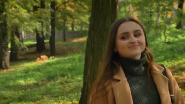 Uzun siyah saçlı beyaz güzel kadının silah, geçiş yeşil güzel işaretlemek, modern stil, rüya yüz ve mutlu vibes, güneşli bir gün.