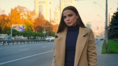 Konsantre beyaz kadın bir kenara araç hareket ve kentsel arka plan, çekilmek üzere bekleyen havada eliyle otostop ile yolun duruyor
