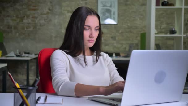 Zakenvrouw werken in het kantoor voor de laptop en voelt verrast — Stockvideo