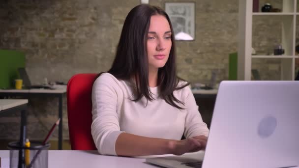 Zakenvrouw voorkant van de laptop, horloges op het scherm en start dansen in haar stoel — Stockvideo