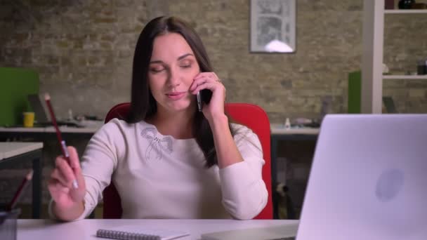 La mujer está hablando por el móvil. sonriendo y riendo y contando sobre smth interesante — Vídeos de Stock