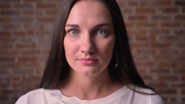 Close-up portret van een vrouw, die in camera horloges en glimlacht puur en oprecht — Stockvideo
