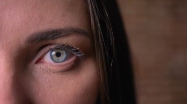 Yakın çekim yarım kameraya cırtlak seyreden bir kadın portresi.