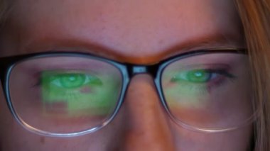 Çok güzel gözleri yakın çekim beyaz hacker kız ile bilgi ekranına bakarak ve bu resimler onun gözlük gibi yansıtır