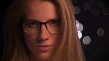 Sarışın güzel beyaz kadın ayakta profil ve gözlük, baş, kapalı, karanlık geçmişini dönüm kameraya bakarak portre