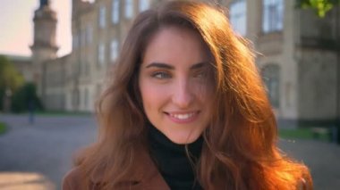 Antik Bina açık havada üzerinde beyaz esmer duran mutlu güzel gülümseme, rahatlatıcı ve güneşli zevk gün düşmek