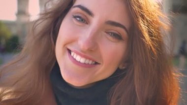 Oldukça yakın çekim portre beyaz muhteşem kadın kameraya güzel doğal gülümseme ile açık havada, sunlights arıyor.