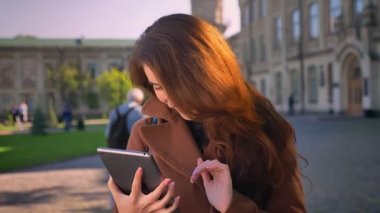 O zaman gösteren yeşil ekran kamera ve işareti gibi güneşli gün açık yüzünde büyük mutlu gülümseme gösteriler güzel beyaz kadın onun tablet swiping