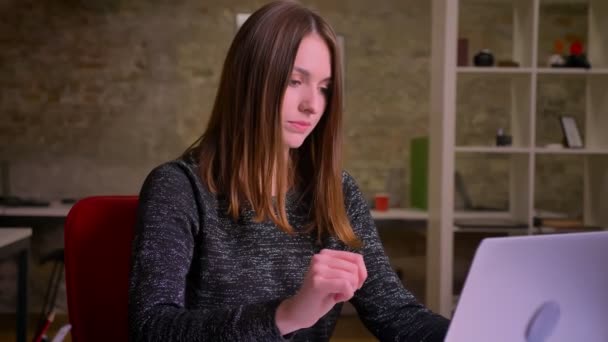 Portrait of serious ginger young business woman, watching on screen of laptop then into the camera . — Stok Video