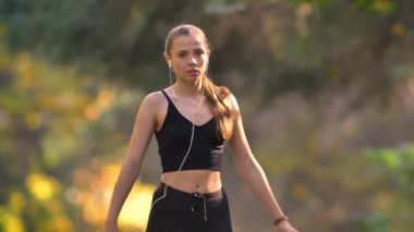 Isınma yapıyor ve sonbahar Park'ta çalışmaya başlayan tulum genç kız portresi yakın çekim