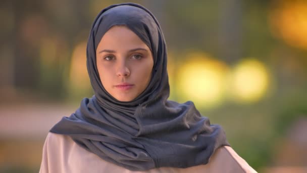 Foto close-up dari gadis Muslim di jilbab menonton ke kamera, melambaikan kepalanya untuk tidak setuju . — Stok Video