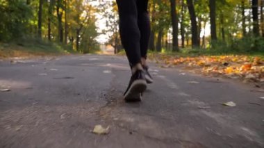 Dolly, sonbahar ormanda koşu hijab Müslüman kız üst ve arka görünümünü alttan vurdu