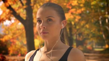 Çalışan ve kulaklık kullanarak müzik genç beyaz kız portresi yakın çekim.