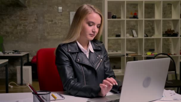 Joyeux caucasien blonde femelle rit et détendu en regardant l'écran d'ordinateur tapant tranquillement sur le clavier, accroché dans le bureau léger sur le lieu de travail — Video