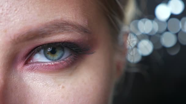 Шикарный зеленый глаз белой женщины крупным планом, красный макияж и черный фон, модные флюиды — стоковое видео