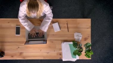 Yukarıdan aşağıya resmen giymiş kadın beyaz gömlekli laptop kullanma office çalışma görünümünü, Dolly vurdu.