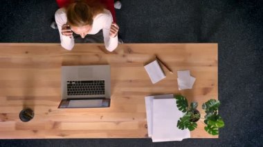 Dolly atış, Kızıl saçlı kadın ofiste cep telefonu üzerinde söz görünümünü aşağı üst.