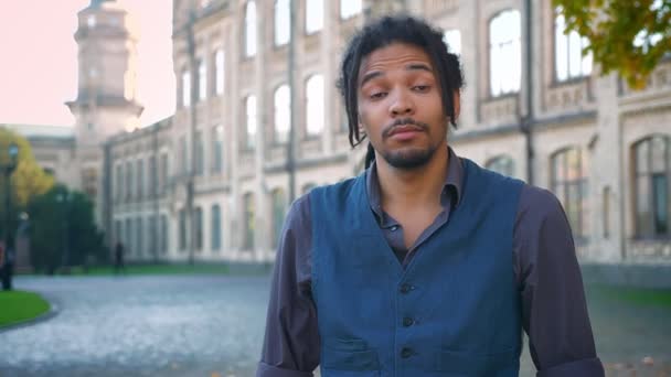 Retrato de jovem afro-americano com dreadlocks se divertindo no fundo da universidade . — Vídeo de Stock