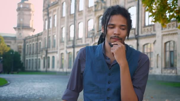 Porträtt av ung afro-amerikansk kille med dreadlocks knäppa fingrarna att visa den ljusa idén på universitet bakgrund. — Stockvideo
