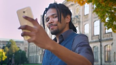 Selfies smartphone Üniversitesi arka plan yapmak için poz dreadlocks ile Afrikalı-Amerikalı öğrenci portresi yakın çekim.