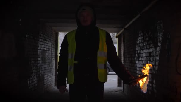 Уверенный молодой человек, стоящий в темном переулке с горящим коктейлем Молотова. Концепция революции . — стоковое видео