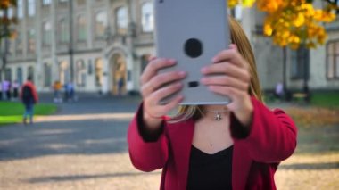 Genç çekici erkek, bir el sallayarak ve ondan uzak gösterilen video aramasý onun tablet üzerinde olan öğrenci saç modeli, üniversite dışında yontmak.