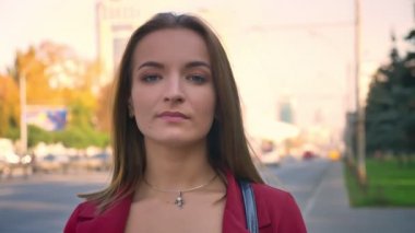 Genç çekici kadın portre sokak, şehir üzerinde duran, gözleri ile azarlama ifade kamera arıyorum