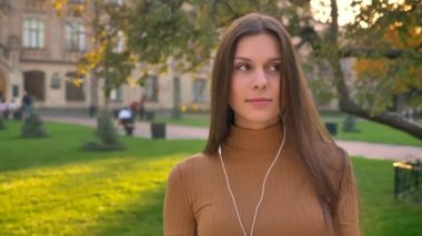 Güzel esmer aktif müzik yeşil park arka plan üzerinde dans portre.