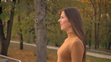 Görünüm çember, dolly eğlenerek ve hayran bir görünüm ile yürüyen Genç beyaz kızın dön alttan vurdu