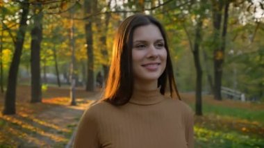 Genç ve güzel beyaz kız saçını güneş ile sonbahar park çevresinde yürüyüş portresi