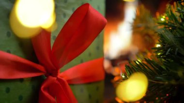 Bir hediye masanın üstüne koy. Arka plan kızdırma şömine bokeh Noel'de üç ışıklar