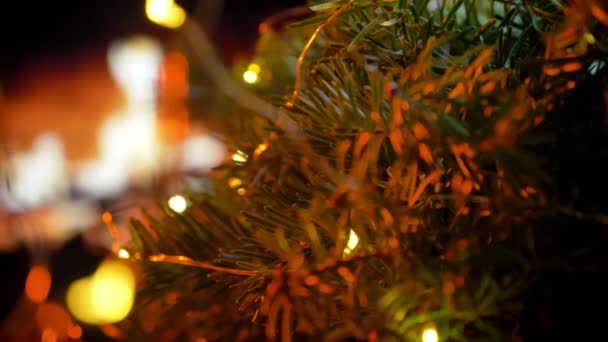 La mano del hombre lleva un regalo sobre la mesa. Navidad tres en brillo chimenea bokeh luces fondo — Vídeos de Stock