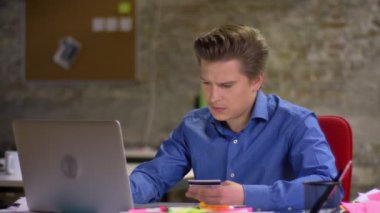 Kredi kartı ve dizüstü bilgisayar kullanma office ikram için ödeme orta yaşlı sarışın işadamı portresi.