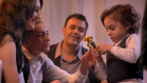 Familia árabe sonriendo jugando con el hijo más pequeño y el robot de juguete en la sala de estar en un ambiente acogedor . — Vídeos de Stock