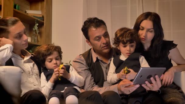 Retrato da família árabe sentado no sofá e observando curiosamente em tablet na sala de estar em ambiente acolhedor . — Vídeo de Stock