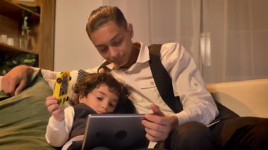 Koltukta yalan ve tablet rahat ve sakin bir atmosferde oturma odasında içine izlerken iki Arapça kardeş portresi.