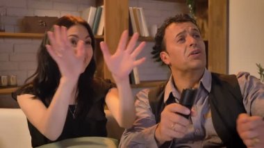 Yakın çekim portre Arapça Tv izlerken güçlü mutluluk ve memnuniyet oturma odasında kanepede oturan ile eşlerin.