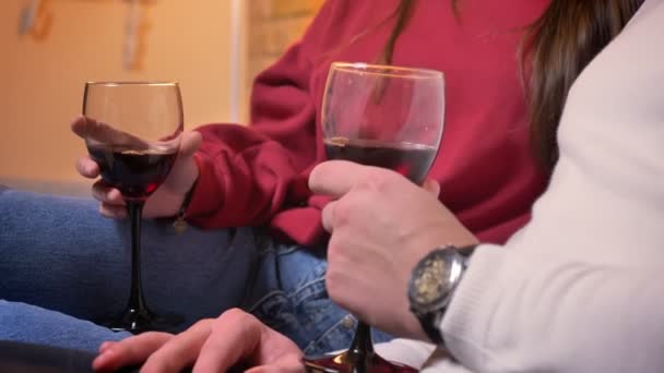 Dolly közeli lövés a kommunikáció iszik bort az otthoni hangulatos kanapén, a kaukázusi fiatal pár. — Stock videók