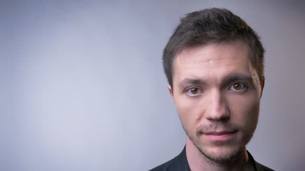 Gros plan du visage de l'homme caucasien attrayant aux yeux bruns et à l'expression faciale neutre — Video