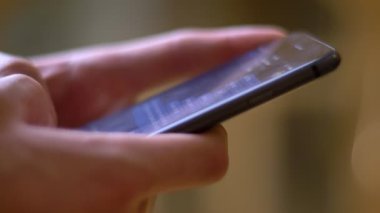 Oda arka plan üzerinde smartphone kullanarak Messenger yazarak profil elinde yakın çekim çekim.