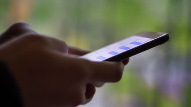 Erkek tipik smartphone bulanık yeşil ışık arka plan üzerinde kullanarak messenger içinde profil elinde kadeh yakın çekim.