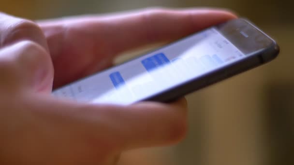 Gros plan des mains masculines dans la saisie de profil dans le messager à l'aide d'un smartphone sur fond de pièce . — Video